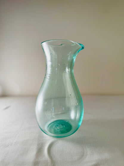 Enyo Living Ocean Green glass carafe with a pouring spout and curved handle. Clear sea-green glass.